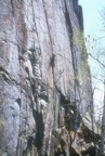 Colin climbs the steep crack of Drop, Fly, or Die, belayed by Joe
