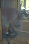 A nasty job, Schelly blows insulation into the bathroom wall